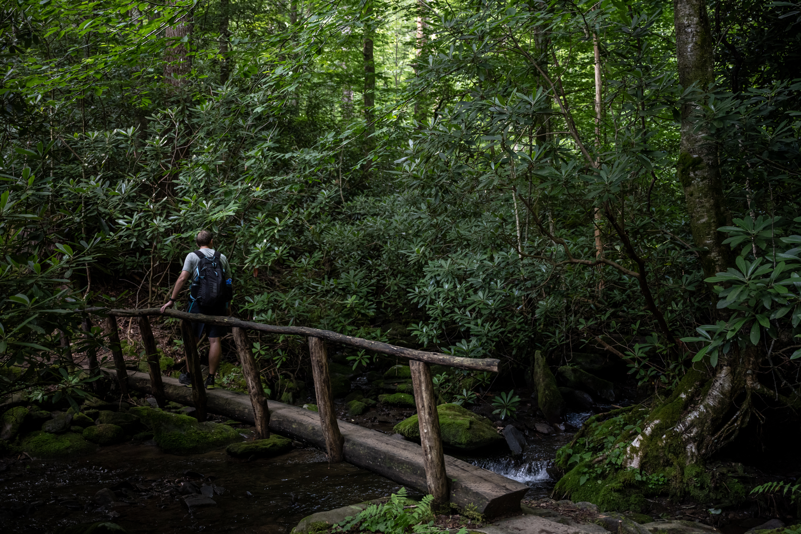hiker crosses bridge