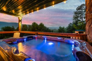 Luxurious hot tub on a sturdy wooden deck surrounded by tall pine trees with a stunning mountain view. Perfect for relaxation and unwinding, the scene evokes tranquility and serenity.